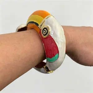 Kleurrijk geëmailleerd toekan vogel scharnier armband detail, levendig metalen sieraad.