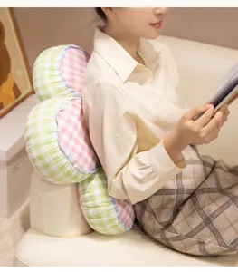 Detailed lifestyle view of a cute checkered flower cushion, cozy sofa back pillow decor.