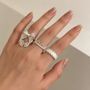 Set van strik en kroon ringen Koreaanse mode, artistiek zilveren sieraden detail.
