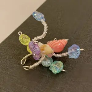 Nahaufnahme des handgefertigten Muschel-Perlenrings im Ozean-Stil, offenes Drahtdesign.