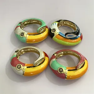 Gedetailleerd overzicht van kleurrijke geëmailleerde toekan vogel metalen armbanden.