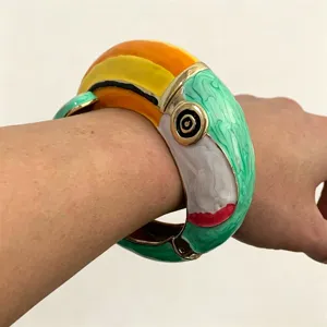 Close-up detailopname van een levendige geëmailleerde papegaai armband om de pols.