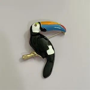 Gedetailleerd overzicht van de kleurrijke emaille toekan vogel broche met vakmanschap.