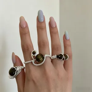 Close-up detail view of unique handmade wire-wrapped gemstone rings featuring stylish design.
