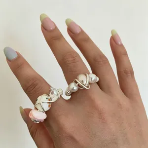 Handmade wire-wrapped pearl ceramic ring detail showing unique layered ring design.