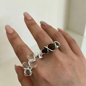 Close-up detail shot of handmade wire-wrapped crystal rings worn on fingers elegantly.