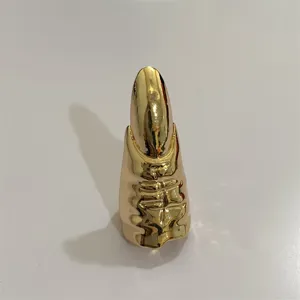 Gedetailleerde close-up van de overdreven gouden venom metalen nagelring met uniek design.