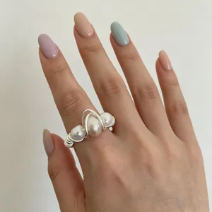 Detail shot of an elegant silver-plated wire-wrapped pearl ring for women's daily wear.