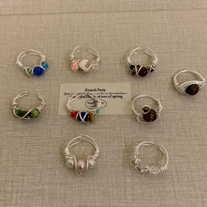 Handmade wire wrapped gemstone and pearl rings detailed close up view with stylish aesthetic.