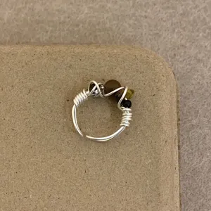 Detailed close-up of handmade wire wrapped ring with natural gemstone beads and unique design.