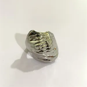Detailopname van de opvallende onregelmatige vloeibare metalen ring met unieke textuur.