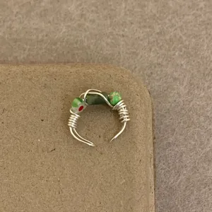 Detailed closeup view of handmade wire wrapped ring featuring colorful beads and wire.