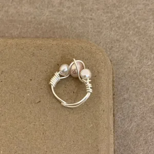 Handmade wire wrapped pearl ring detail view, minimalist style jewelry close up shot for women.