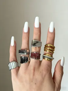Primo piano dettagliato che mostra diversi anelli eleganti in smalto metallico rigato e lucidato.