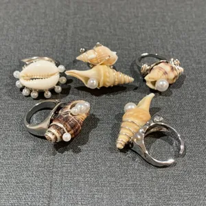 Ensemble de bagues perles coquillage naturel fait main, bijou fil métal style océan détail.