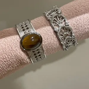 Detailopname van zilveren ajourringen met tijgeroogsteen en schitterende zirkonia.