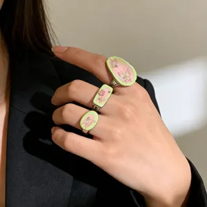 Detailed shot of Y2K sweet cool enamel butterfly rings, pink and green contrast jewelry for women.