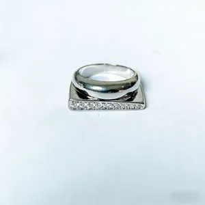 Close-upweergave van de unieke geometrische zilveren ring met sprankelende strass-kristaldetails.