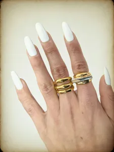 Primo piano dettagliato di un anello in metallo multistrato largo con finitura bicolore.