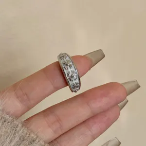 Primo piano dettaglio anello croce argento smalto bianco, foto dettaglio stile hip hop.