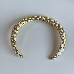 Collar gargantilla abierto dorado con detalles de incrustaciones de esmalte blanco, detalle.
