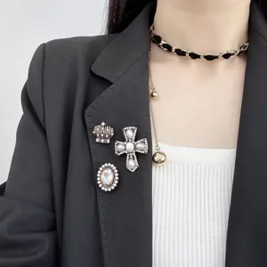 Vintage style cross and crown brooch set with faux pearls and rhinestones, elegant accessory.