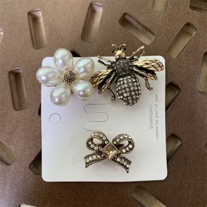 Vintage rhinestone bee pearl flower bow brooch detail shot fashion jewelry accessory