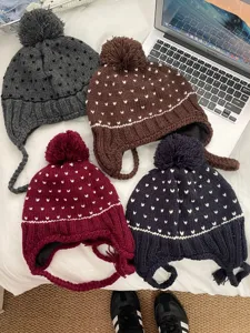 Detail shot of Korean style cute pompom knit earflap hat in multiple winter colors.