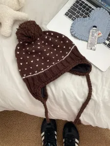 Detailed view of the Korean style cute knitted pompom hat with warm earflaps and cute heart patterns.
