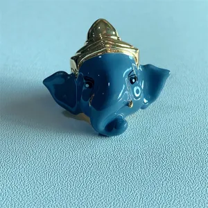 Vista dettagliata dell'anello elefante Ganesha in smalto blu con corona d'oro, gioiello unico elegante.