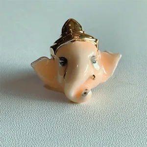 Vista dettagliata di un anello elefante Ganesha in smalto unico con corona d'oro da donna.