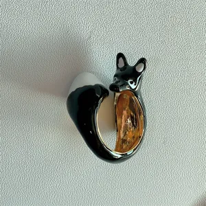 Anello animale in smalto nero con punta della coda bianca e fascia interna dorata.