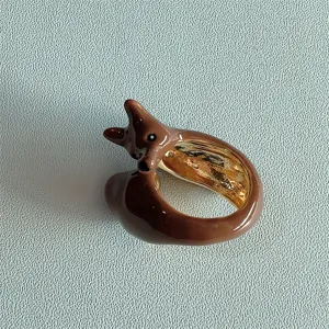 Vista dettagliata di un grazioso anello animale in smalto marrone con fascia interna.