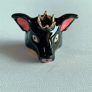 Primo piano di un anello di animale in smalto nero con corona dorata, elegante e unico.