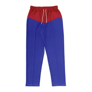 Close-up of casual color-block straight-leg pants with red waist, blue legs and drawstring.