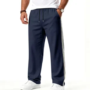 Pantalon de survêtement sportif ample pour homme avec cordon et bandes contrastées.