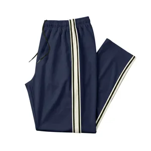Détail du pantalon de survêtement bleu pour homme avec bandes latérales et cordon de serrage.