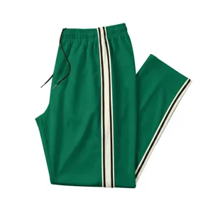 Détail pantalon de survêtement vert, pantalon de sport décontracté avec bande latérale et cordon.