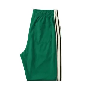 Vue détaillée du pantalon de survêtement vert pour homme avec bandes contrastées.