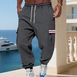 Vista dettagliata di pantaloni cargo felpati da uomo grigio scuro con coulisse e tasche.