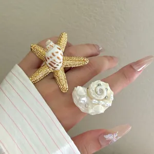 Detailansicht von Meeres-Urlaubsstil Seestern und Muschel Ring Stapel, handgefertigt.