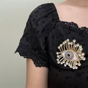 Détail de broche strass œil maléfique rétro, bijoux de mode en cristal doré exhorbitant.
