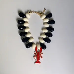 Collier ras de cou tendance perles noir et blanc avec pendentif homard rouge pour femme