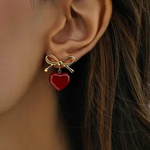 Detailed shot of stainless steel sweet heart bow earrings, stylish and cute fashion jewelry.