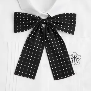 Nahaufnahme Detail einer klassischen schwarz-weißen Pünktchen JK Uniform Schleife auf Hemd.
