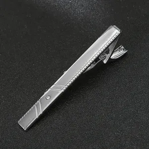 Silver metal tie clip detail shot, elegant business accessory with sparkling crystal accent.