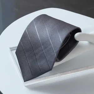 Dark grey striped necktie close-up, premium formal business suit tie detail view.