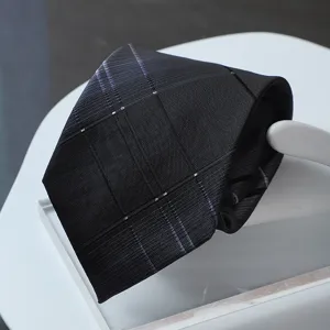 Close up detail view of a dark business formal necktie featuring fine woven stripe texture.