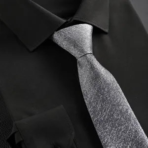 Detailed view of a silver shimmering tie paired with a classic black dress shirt for business formal wear.
