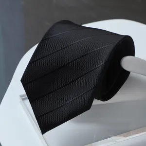 Detail view of black formal business tie with textured stripes. Premium men's accessory.